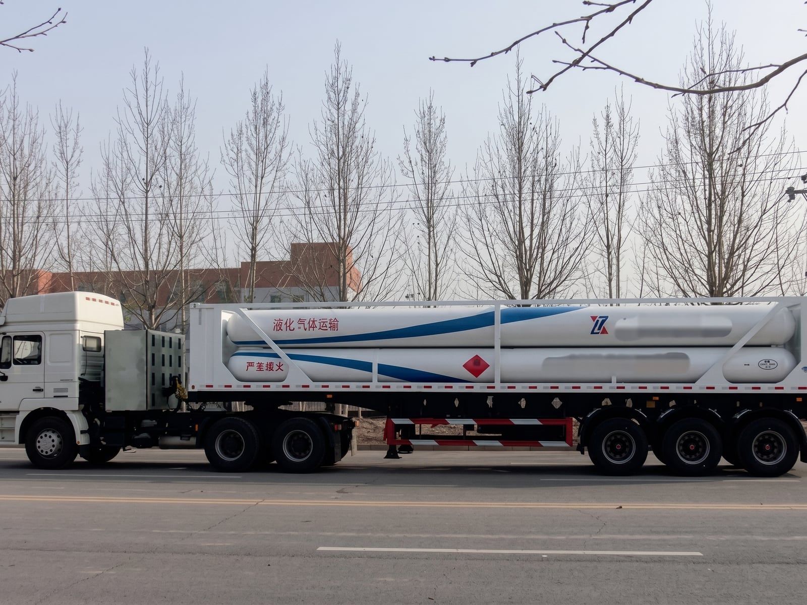 CNG Transport Semi-Trailer seen from the side on the road, the cylinder bundle in its frame, coupled to a prime mover