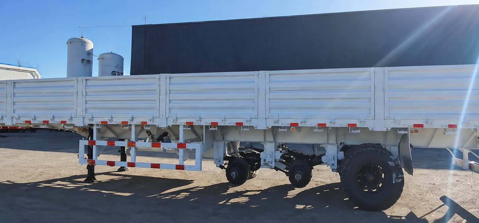 CYP9400L 800 mm Drop-Side Semi-Trailer seen from the side at a distance, drop sides up, landing legs down