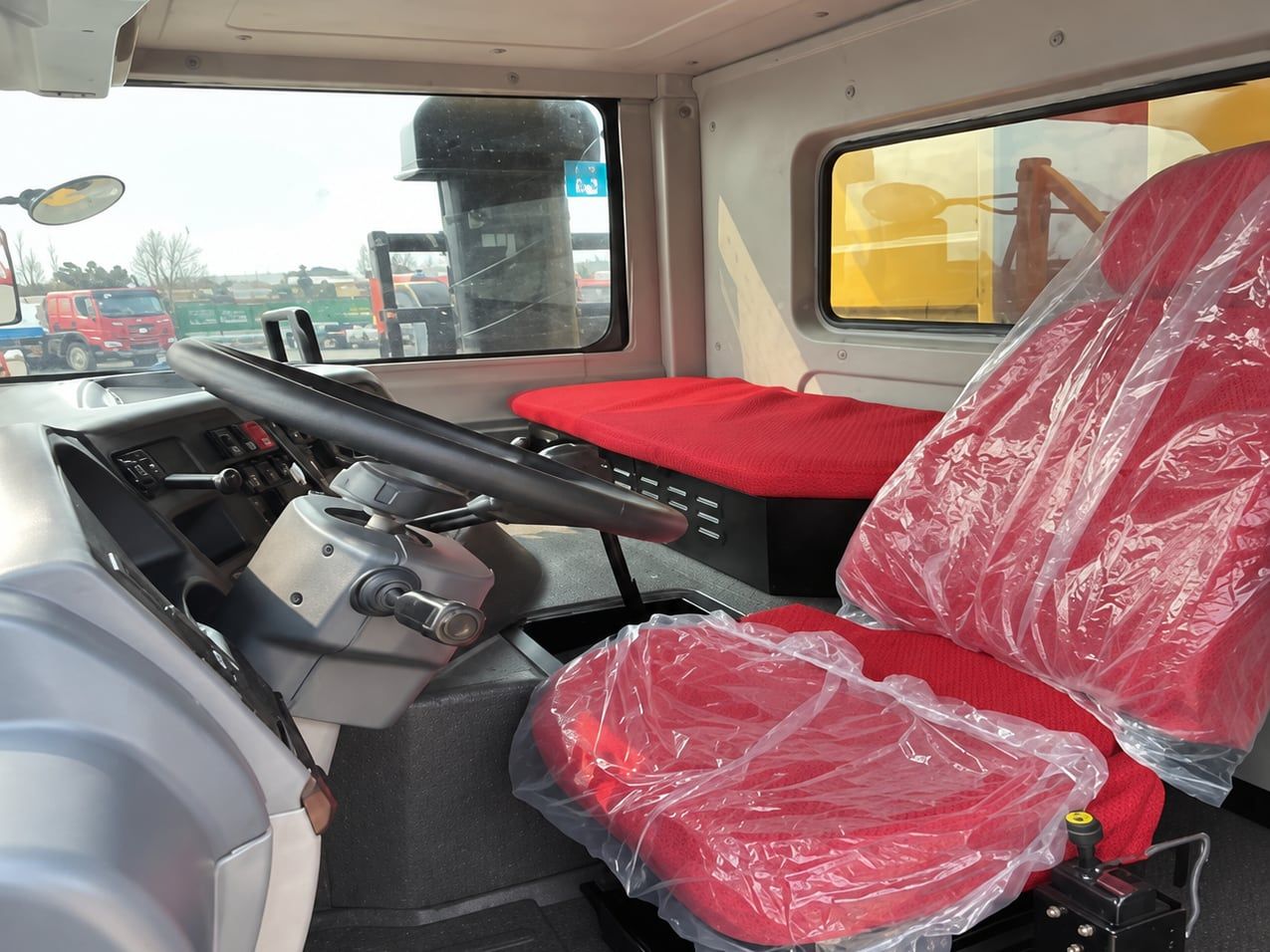 SDLG Wide-Body Mining Truck inside the cab: left-hand drive position, seat still wrapped in delivery plastic