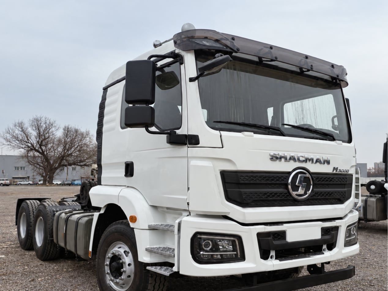 Shacman Delong H3000 6×4 Tractor Truck photographed three-quarter front, white Shacman cab, fifth wheel empty