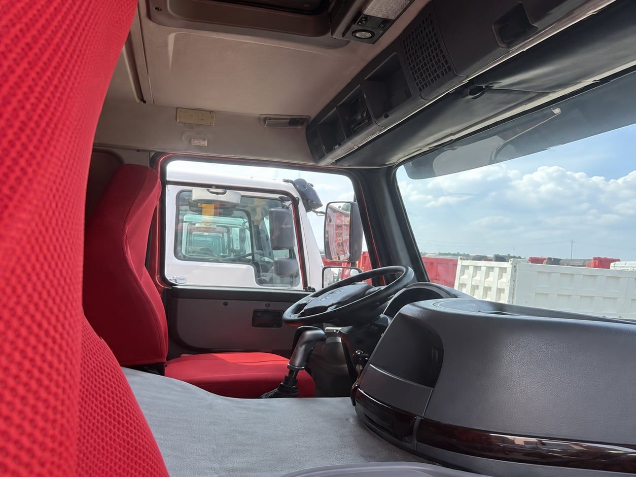 Sinotruk HOWO 6×4 Dump Truck inside the cab: left-hand drive position, steering wheel, dashboard and red upholstery