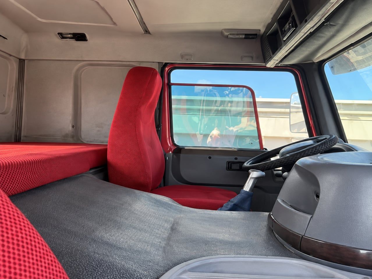 Sinotruk HOWO 6×4 Water Truck inside the cab: left-hand drive position, red upholstery and dashboard