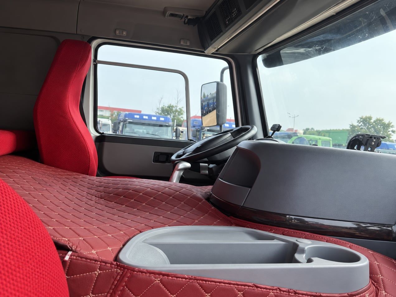 Sinotruk HOWO 8×4 Dump Truck inside the cab: left-hand drive position, red quilted upholstery and dashboard