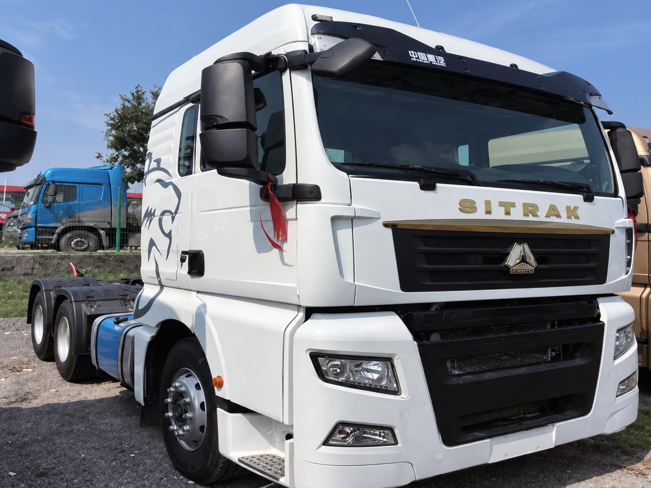 Sinotruk SITRAK 6×4 Tractor Truck photographed three-quarter front, white SITRAK cab, fifth wheel empty