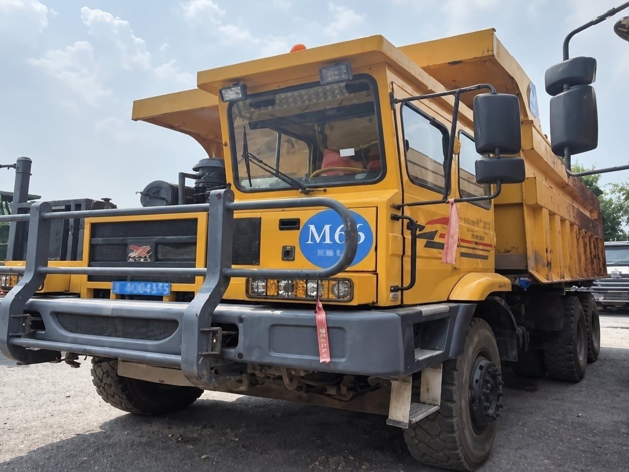 Tonly Wide-Body Mining Truck photographed front three-quarter, yellow cab and bull bar, dump body empty